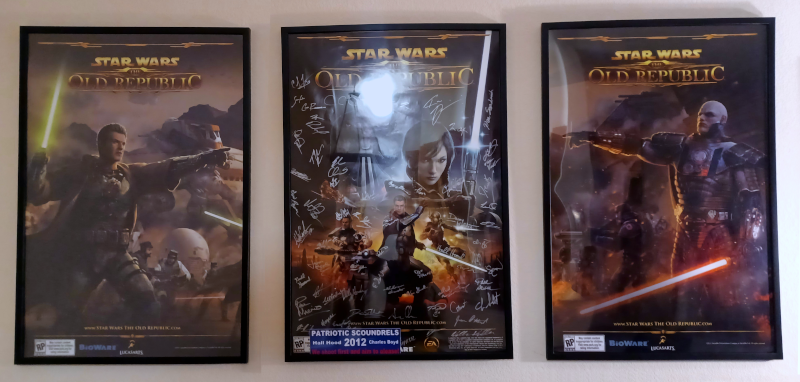 Three SWTOR posters, with the center signed by the team.